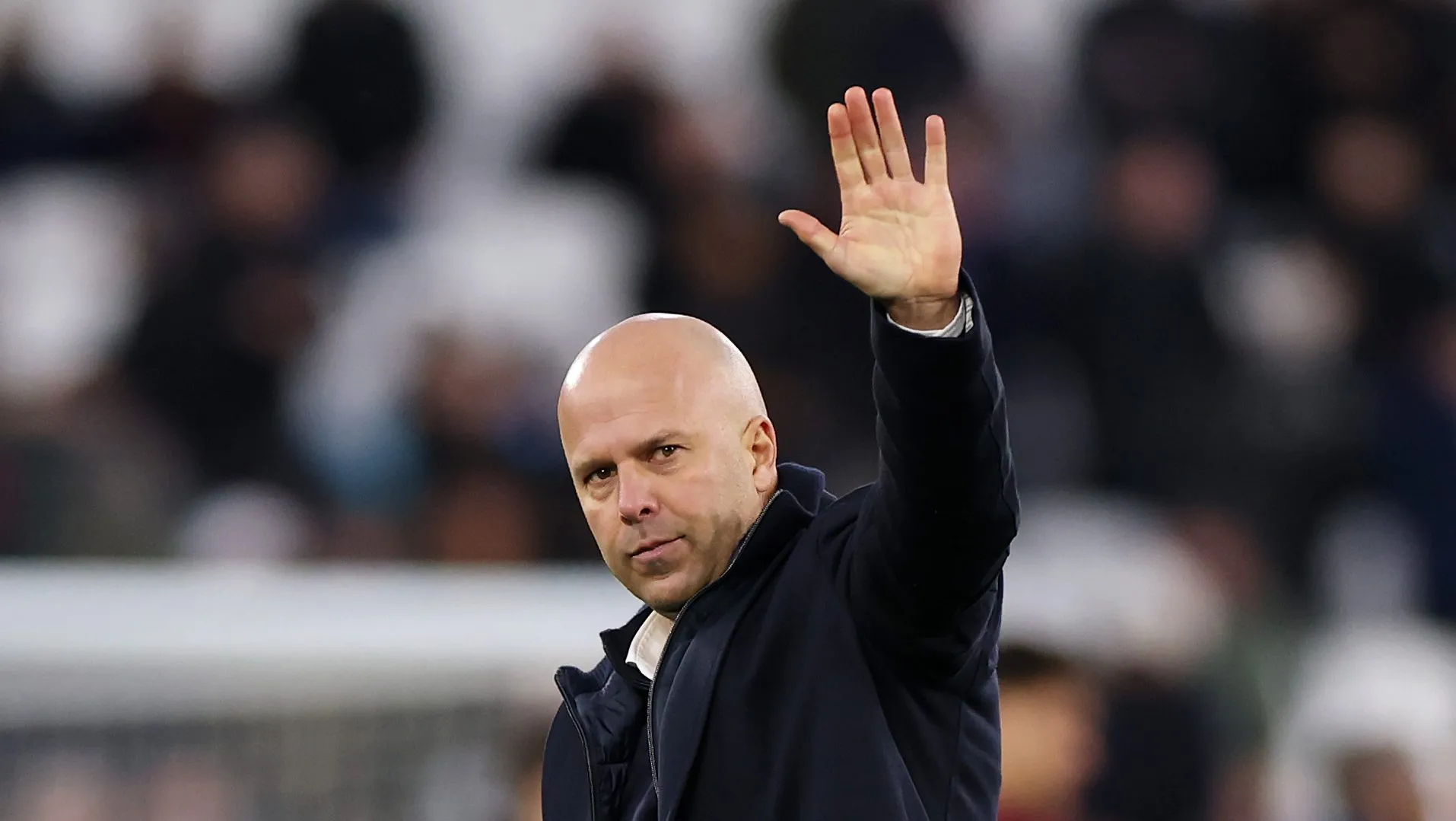 Arne Slot acenando ao lado de Szoboszlai com a camisa alternativa do Liverpool