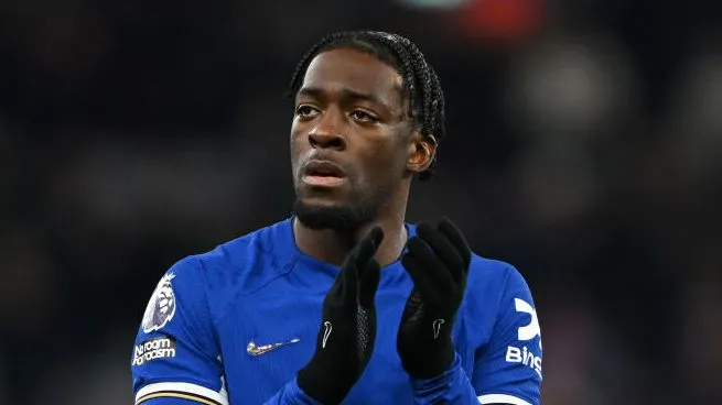 Axel Disasi, em campo, aplaudindo, de camisa azul do Chelsea