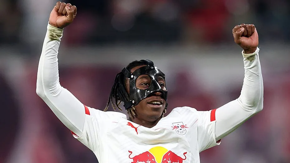 Yan Diomande, do RB Leipzig, em campo, de máscara facial, comemorando