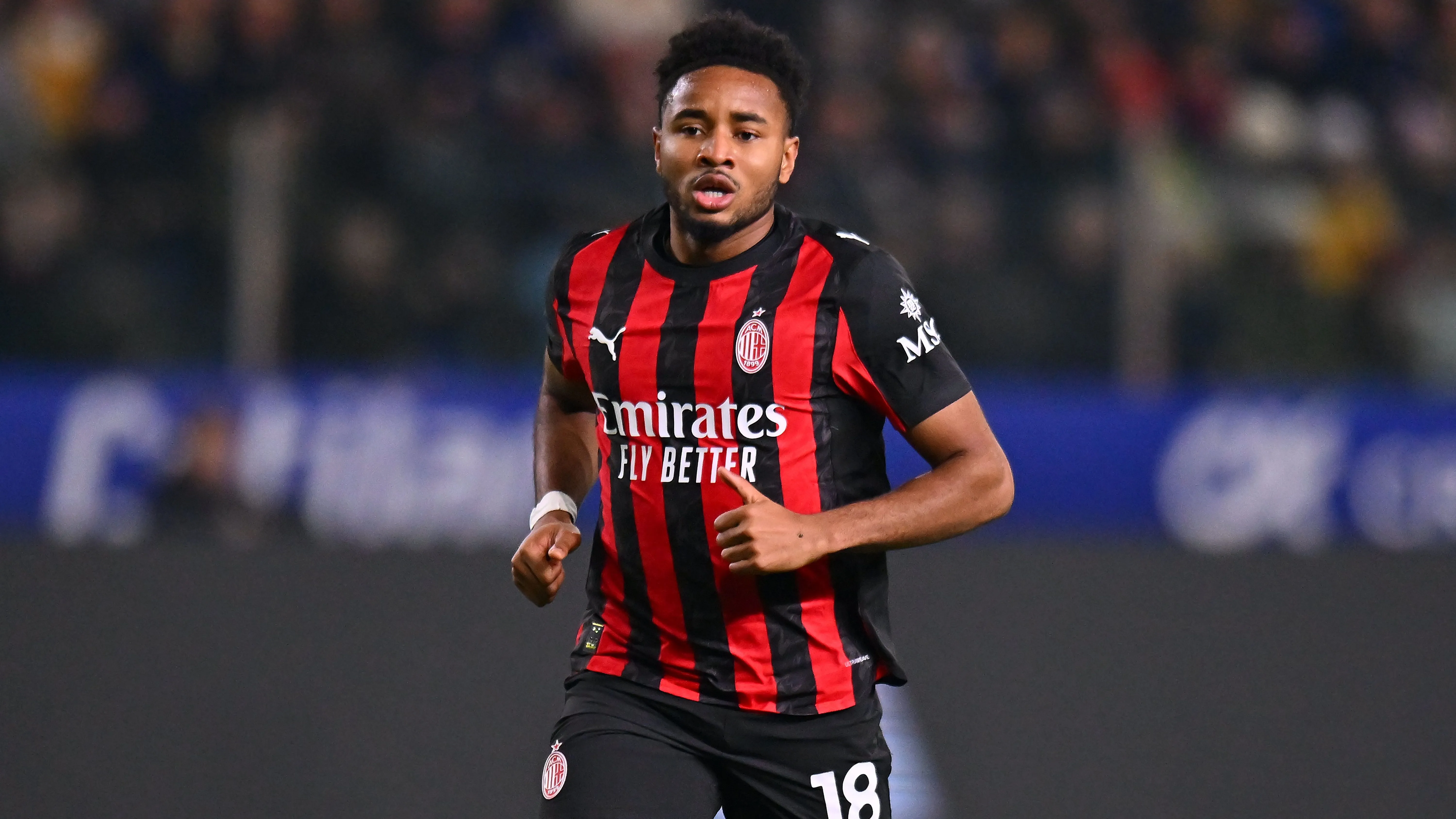 Nkunku em jogo do Milan com camisa vermelha e preta. Foto: Alessandro Sabattini/Getty Images