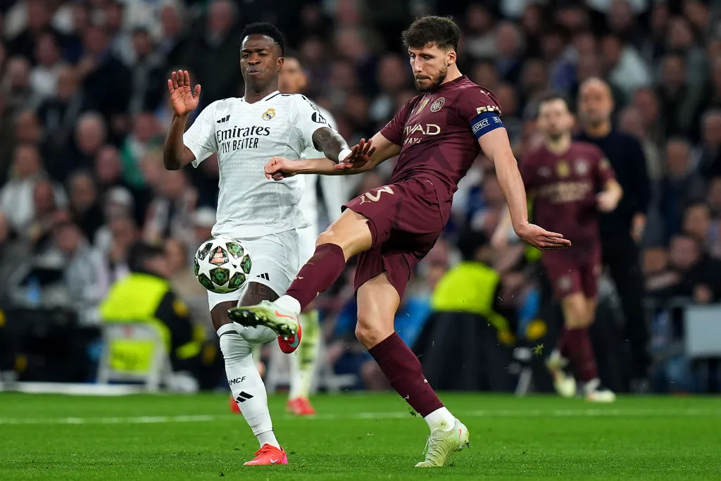 Vinicius Junior, do Real Madrid, disputa a posse de bola com Ruben Dias, do Manchester City, durante o jogo de volta da fase eliminatória da Liga dos Campeões da UEFA 2024/25 entre Real Madrid CF e Manchester City, no Estádio Santiago Bernabéu, em 19 de fevereiro de 2025, em Madri, Espanha. (Foto de Angel Martinez/Getty Images)