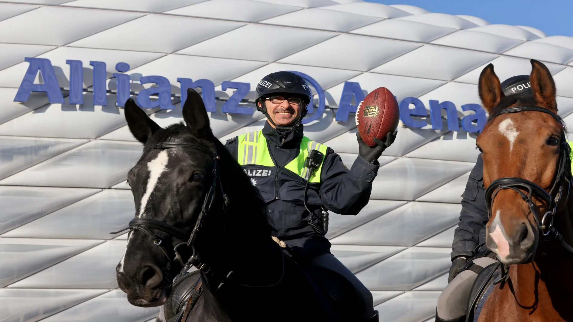 Policial alemão com bola de futebol americano em frente ao Allianz Arena – Alexandra Beier/Getty Images