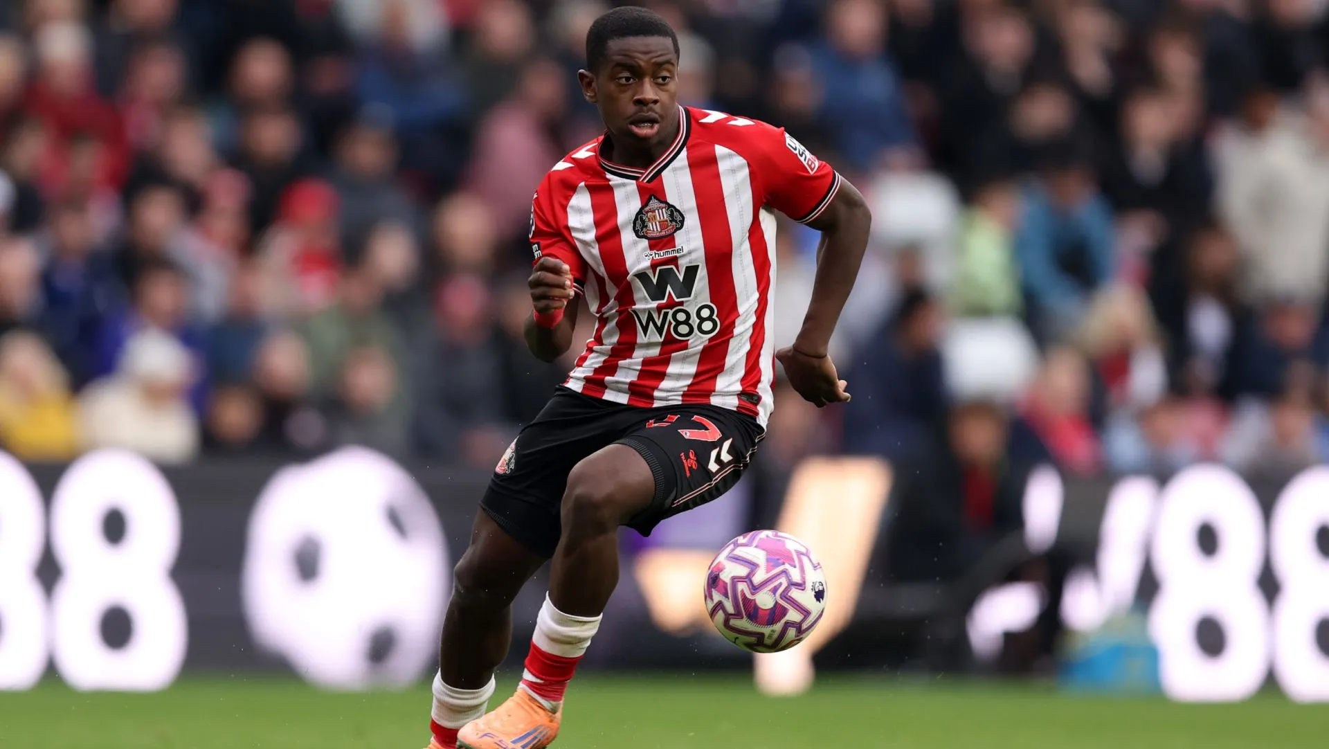 Noah Sadiki corre com a bola durante partida da Premier League. Foto: George Wood/Getty Images