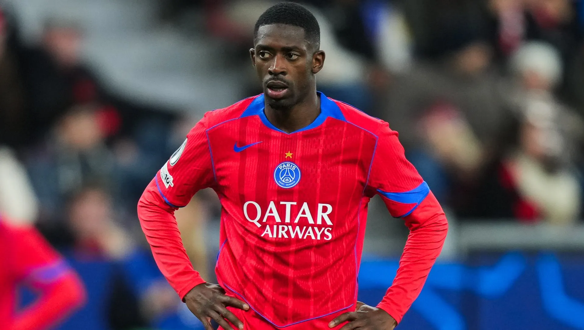 Dembélé em jogo do PSG com camisa vermelha e azul. Foto: Pau Barrena/Getty Images