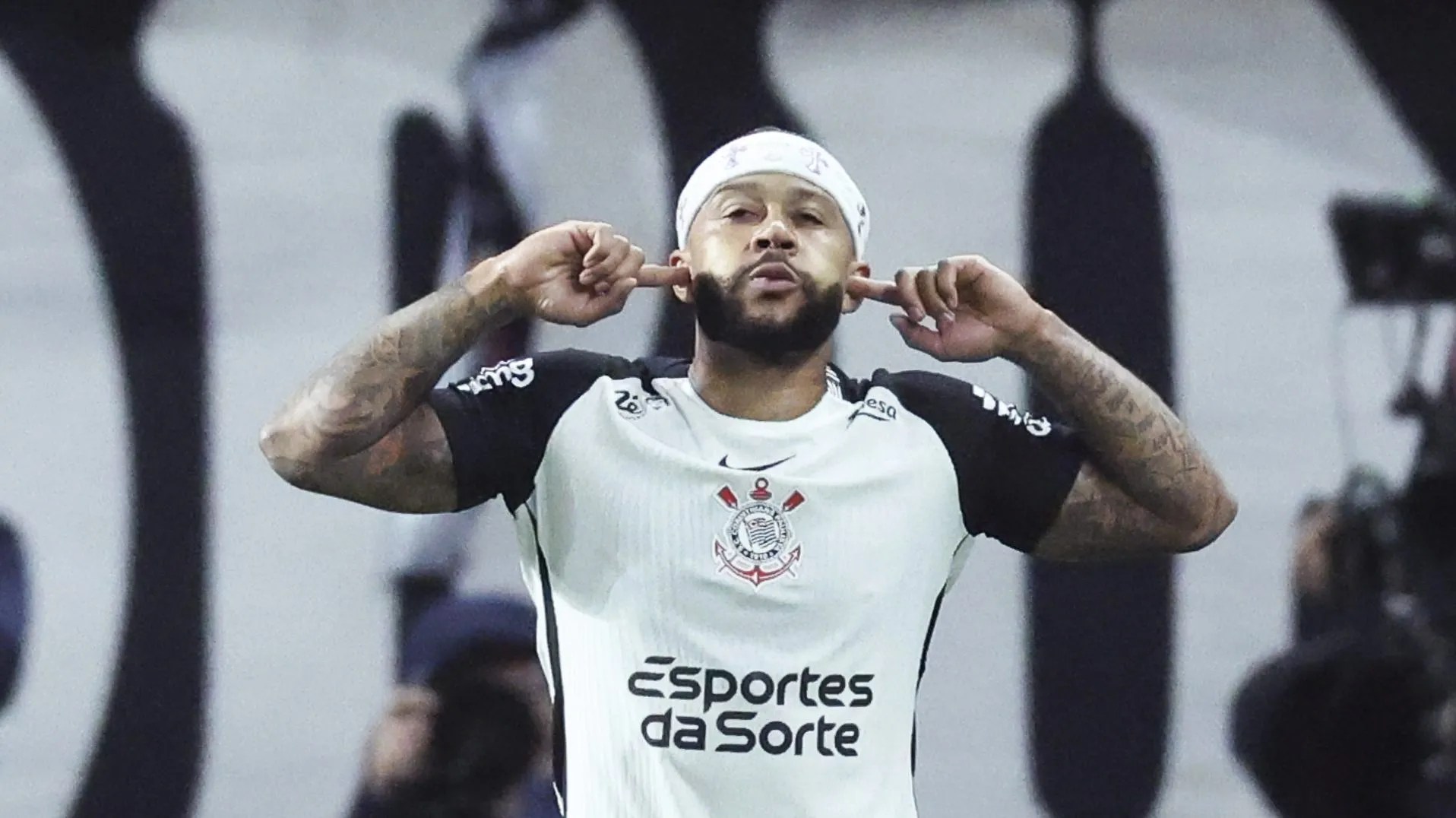 Memphis Depay celebrando com os dedos no ouvindo em jogo do Corinthians
