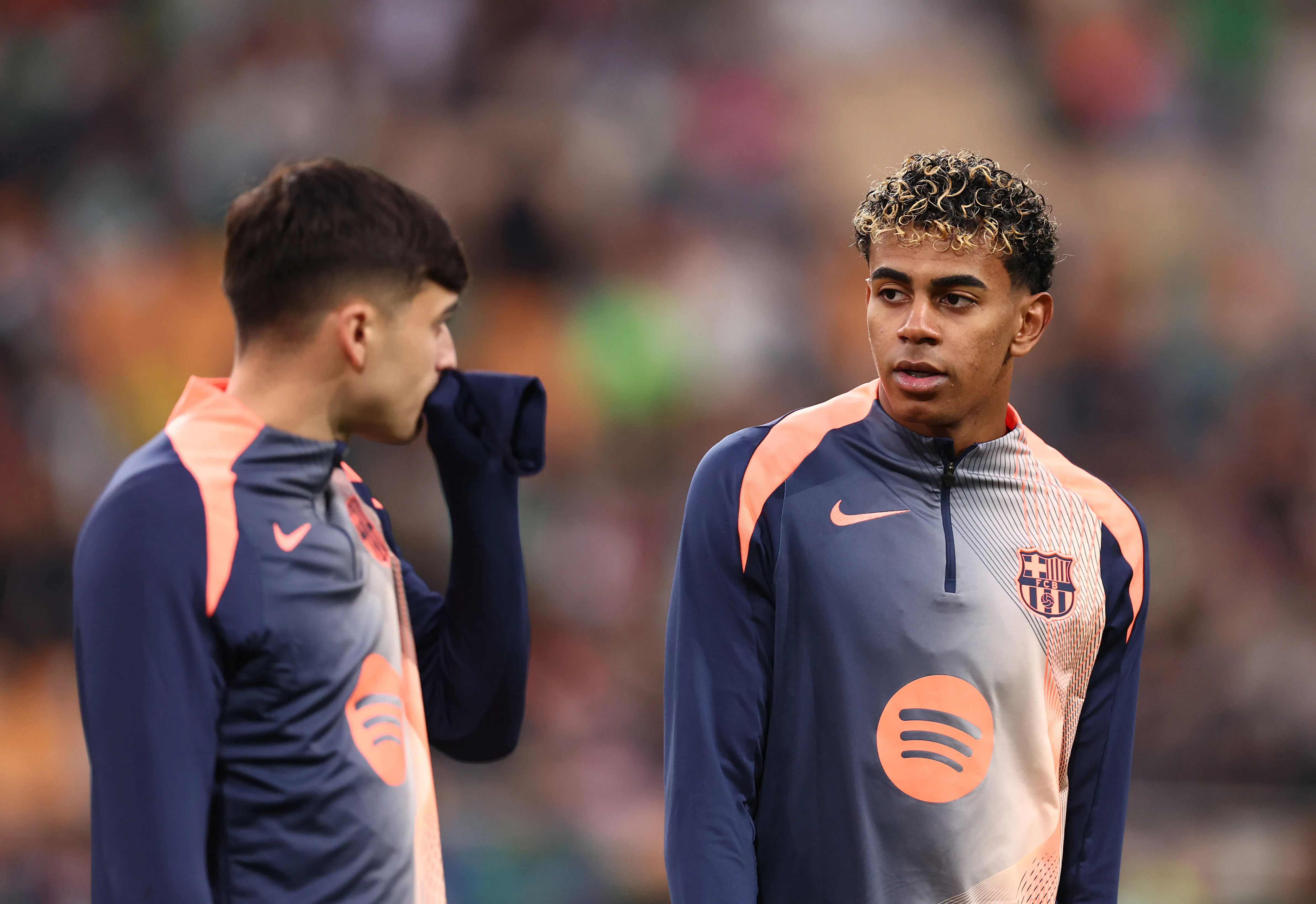 Lamine Yamal, do FC Barcelona, interage com o companheiro Pedri durante o aquecimento antes da partida da LaLiga EA Sports entre Real Betis Balompié e FC Barcelona, no Estadio La Cartuja, em 6 de dezembro de 2025, em Sevilha, Espanha. (Foto: Fran Santiago/Getty Images)