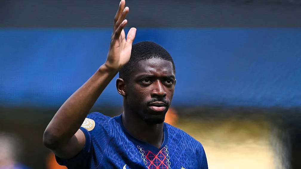 Dembélé, em campo, acenando com a mão