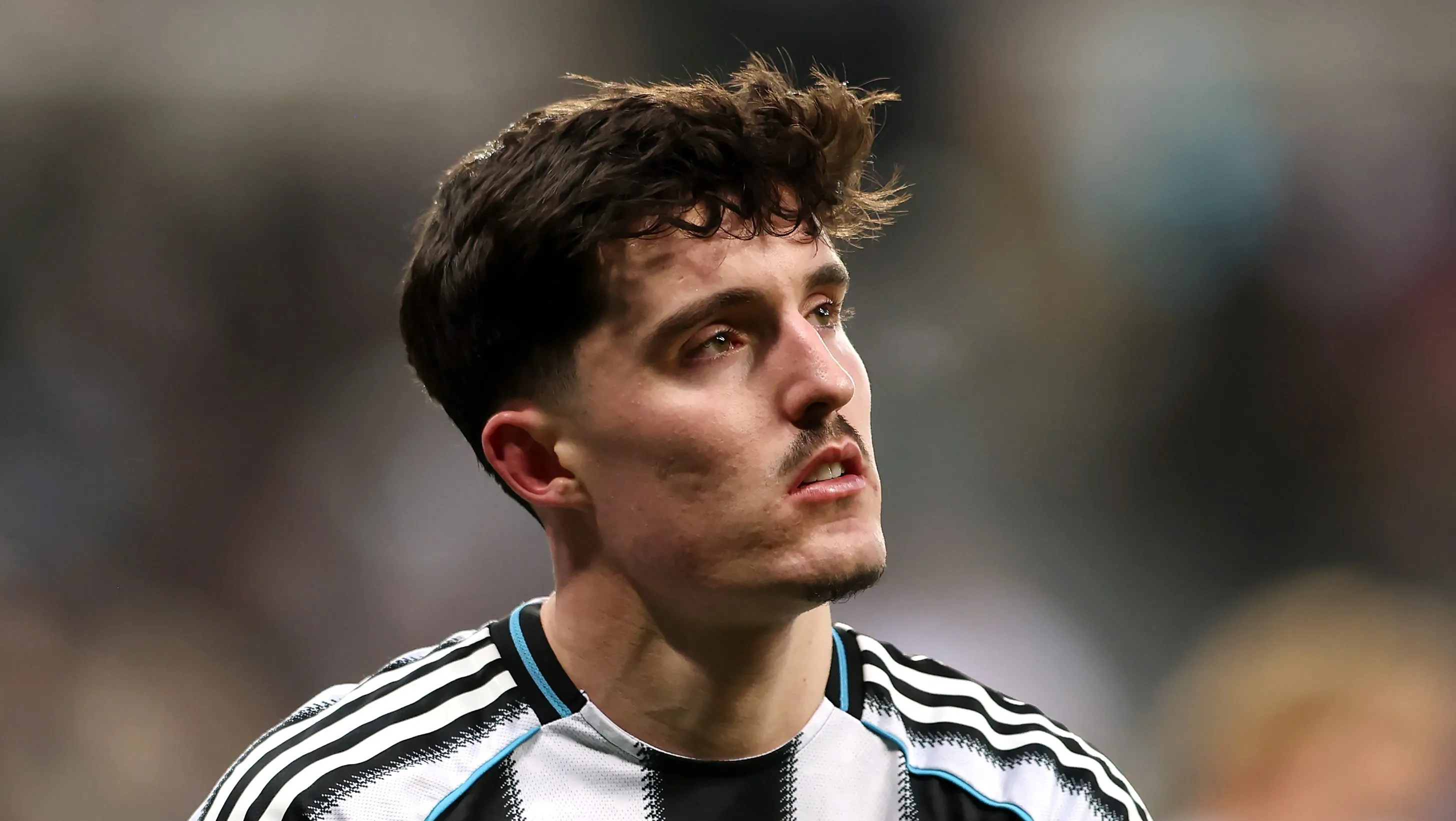 Tino Livramento olha para cima usando a camisa do Newcastle