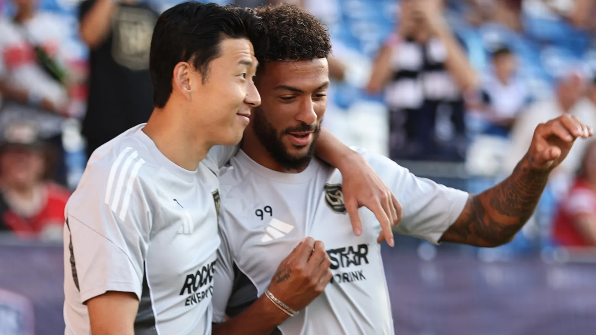 Denis Bouanga abraçado com Son, em jogo do LAFC