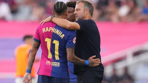 Raphinha e Hansi Flick abraçados em jogo do Barcelona

