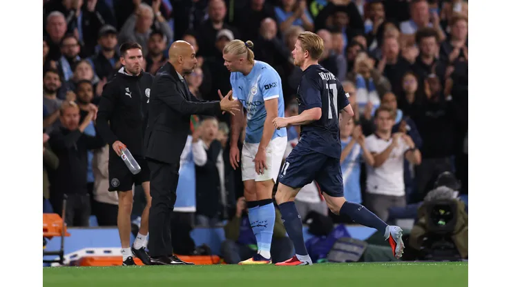 Kevin De Bruyne, do Napoli, deixa o campo após ser substituído, enquanto Pep Guardiola, treinador do Manchester City, fala com Erling Haaland, do Manchester City, durante a partida da 1ª rodada da fase de liga da UEFA Champions League 2025/26 entre Manchester City e SSC Napoli, no City of Manchester Stadium, em 18 de setembro de 2025, em Manchester, Inglaterra. (Foto de Ryan Pierse/Getty Images)