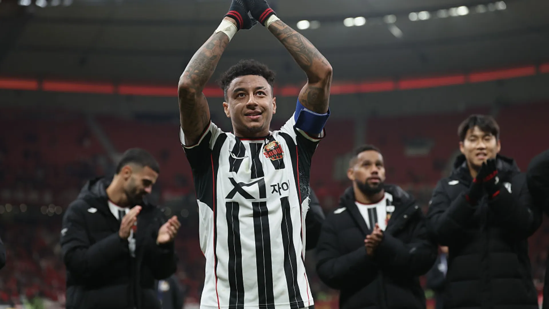 Jesse Lingard, com braços para o alto aplaudindo, em jogo