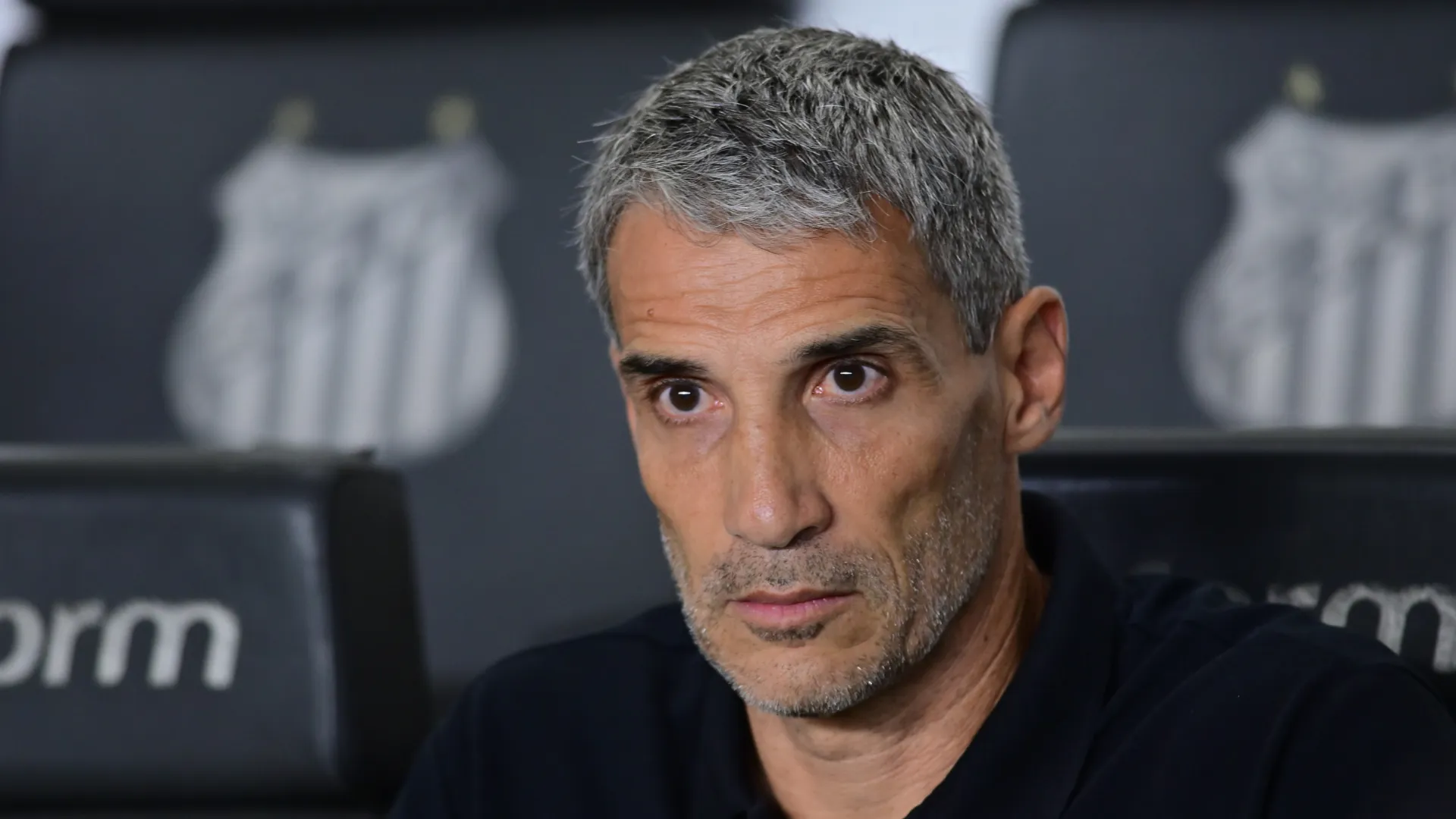 Juan P. Vojvoda sentado no banco de reservas em jogo do Santos