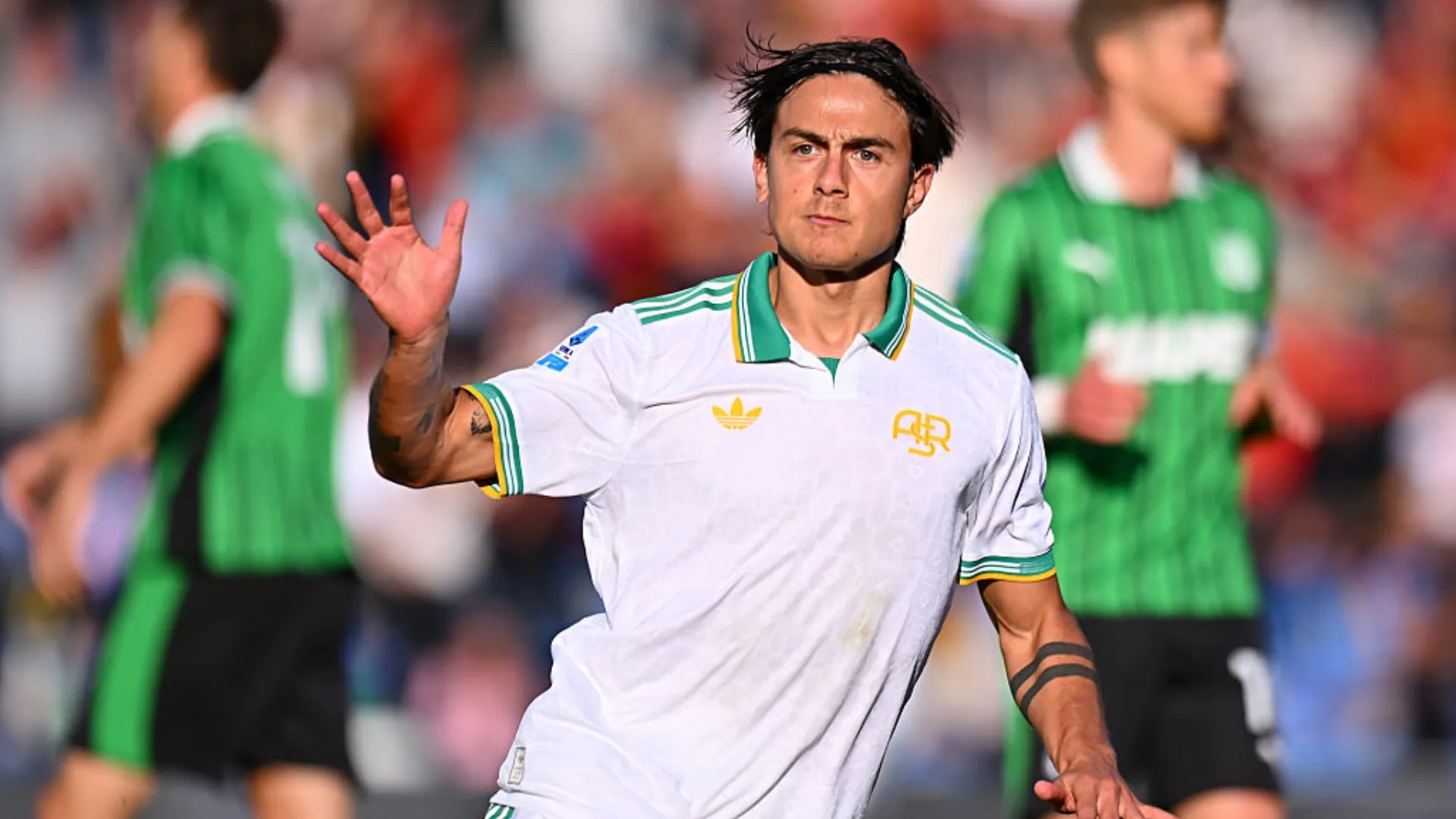 Dybala com a mão para o alto durante jogo da Roma