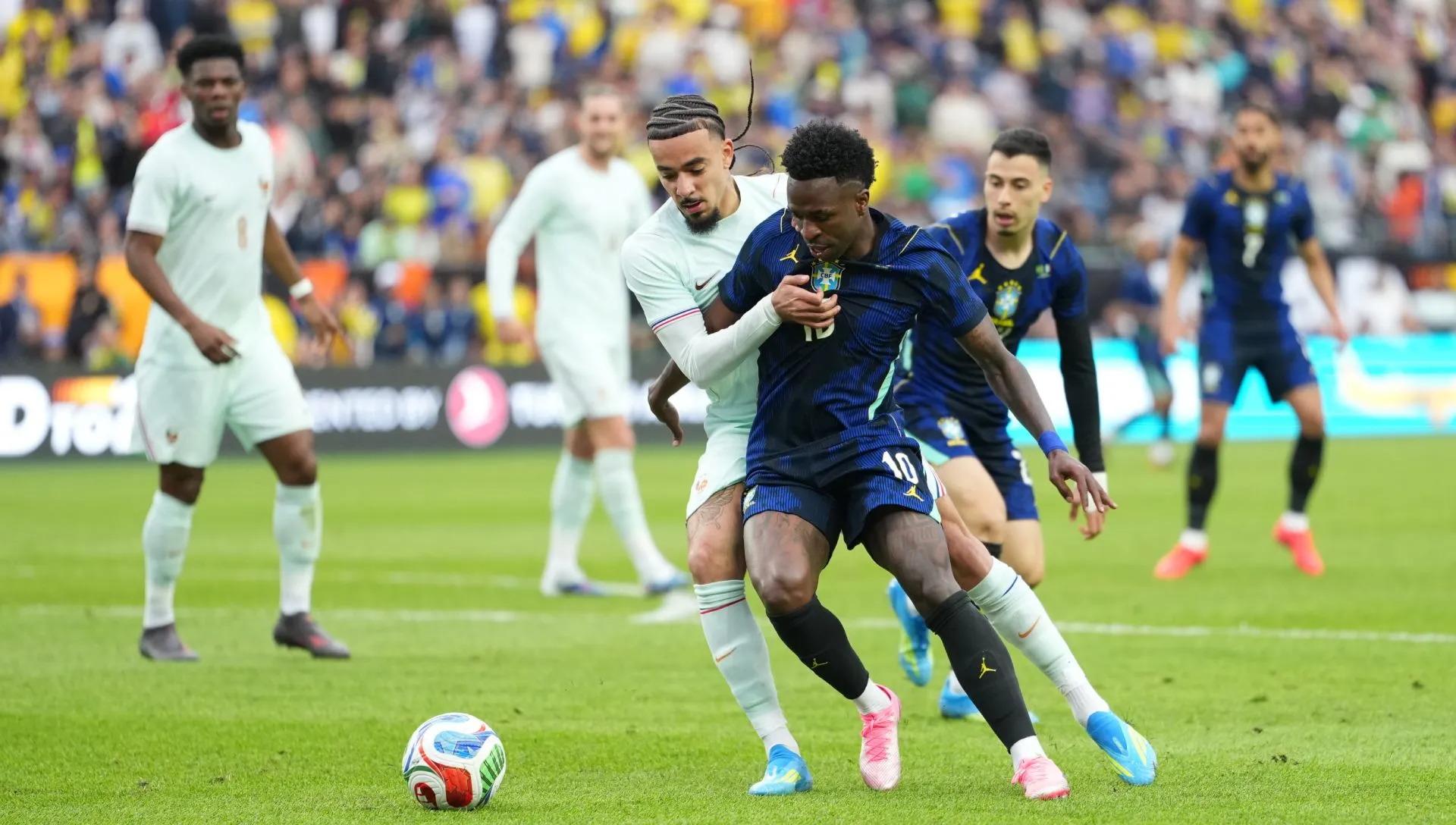 Vini Júnior, do Brasil, luta pela bola com Malo Gusto, da França, durante amistoso. Foto: Michael Owens/Getty Images