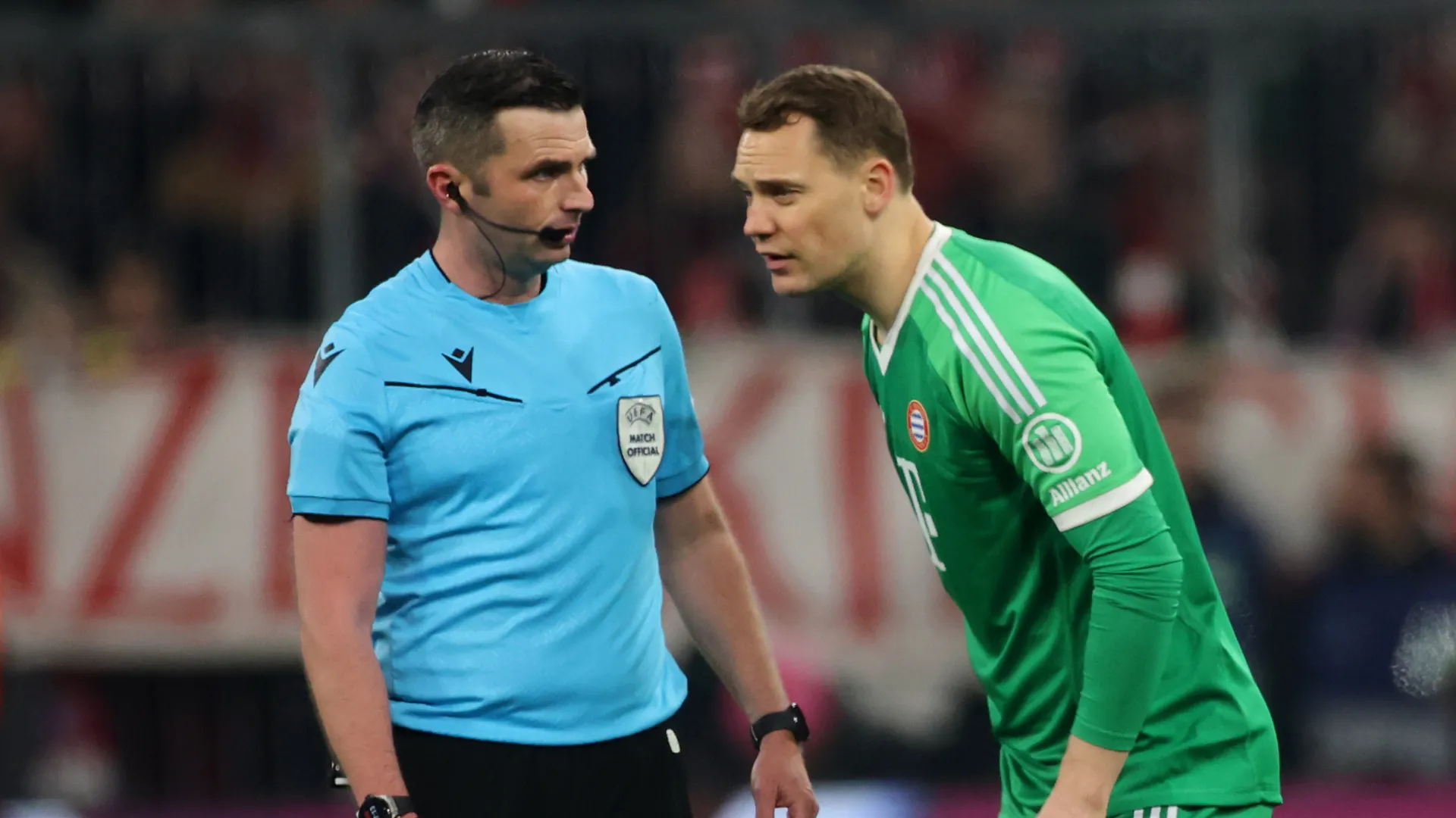 Michael Oliver conversa com Manuel Neuer