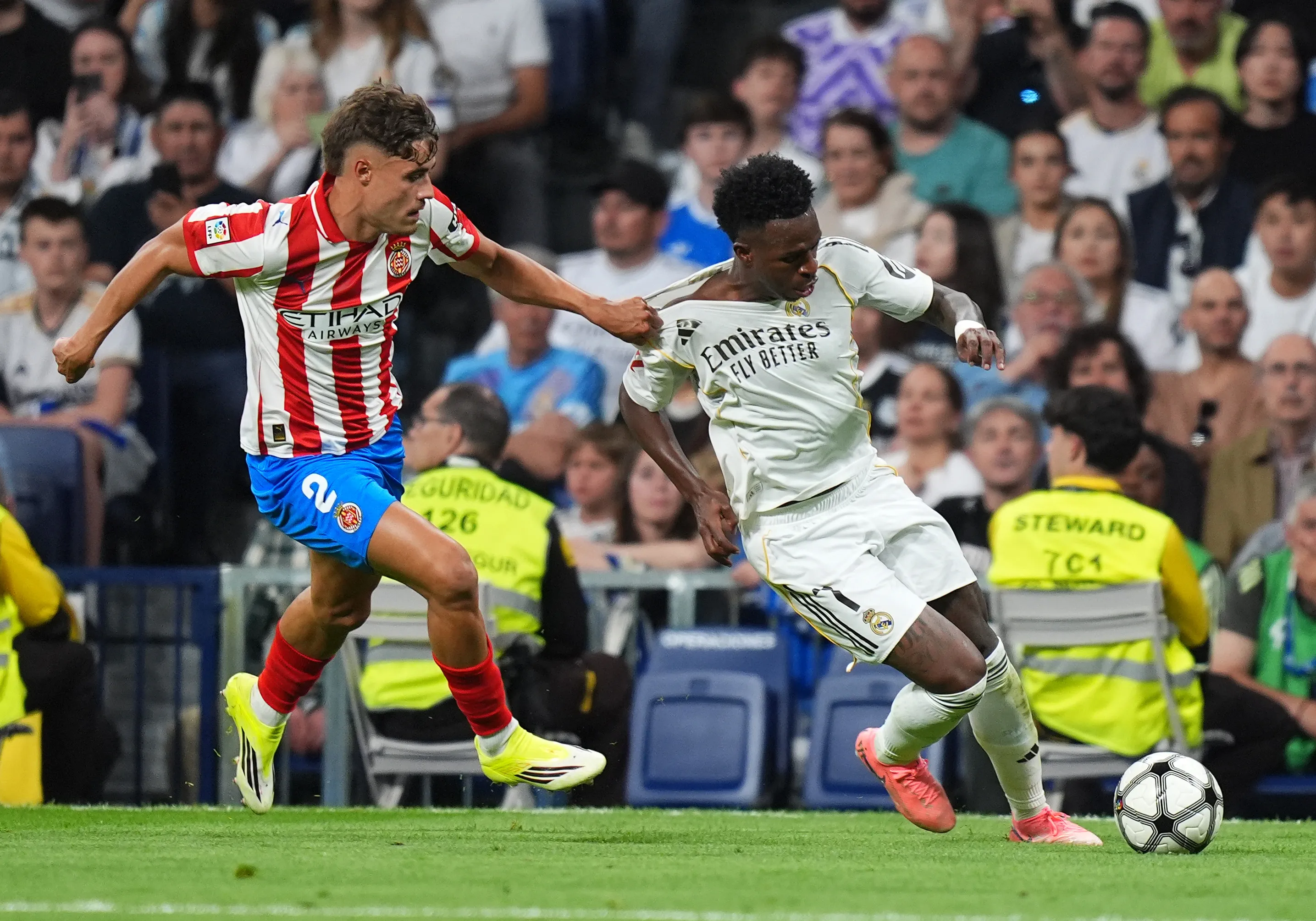 Vinicius Junior do Real Madrid é desafiado por Hugo Rincon do Girona FC durante a partida da LaLiga EA Sports entre Real Madrid CF e Girona FC no Estádio Santiago Bernabéu, em 10 de abril de 2026, em Madrid, Espanha. (Foto de Angel Martinez/Getty Images)