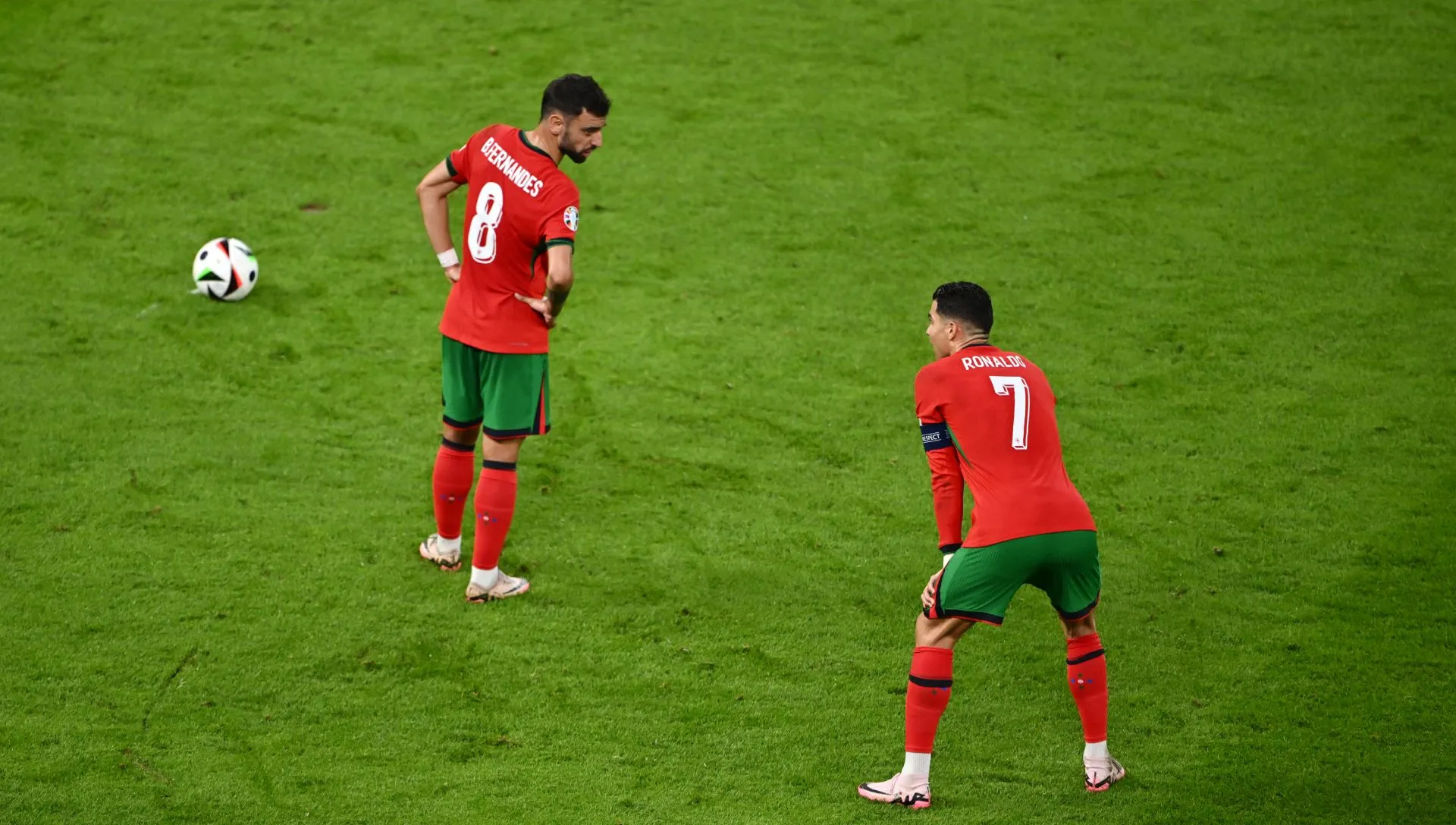 Bruno Fernandes fala com Cristiano Ronaldo enquanto se preparam para uma cobrança de falta durante a partida da UEFA EURO 2024. Foto: Dan Mullan/Getty Images