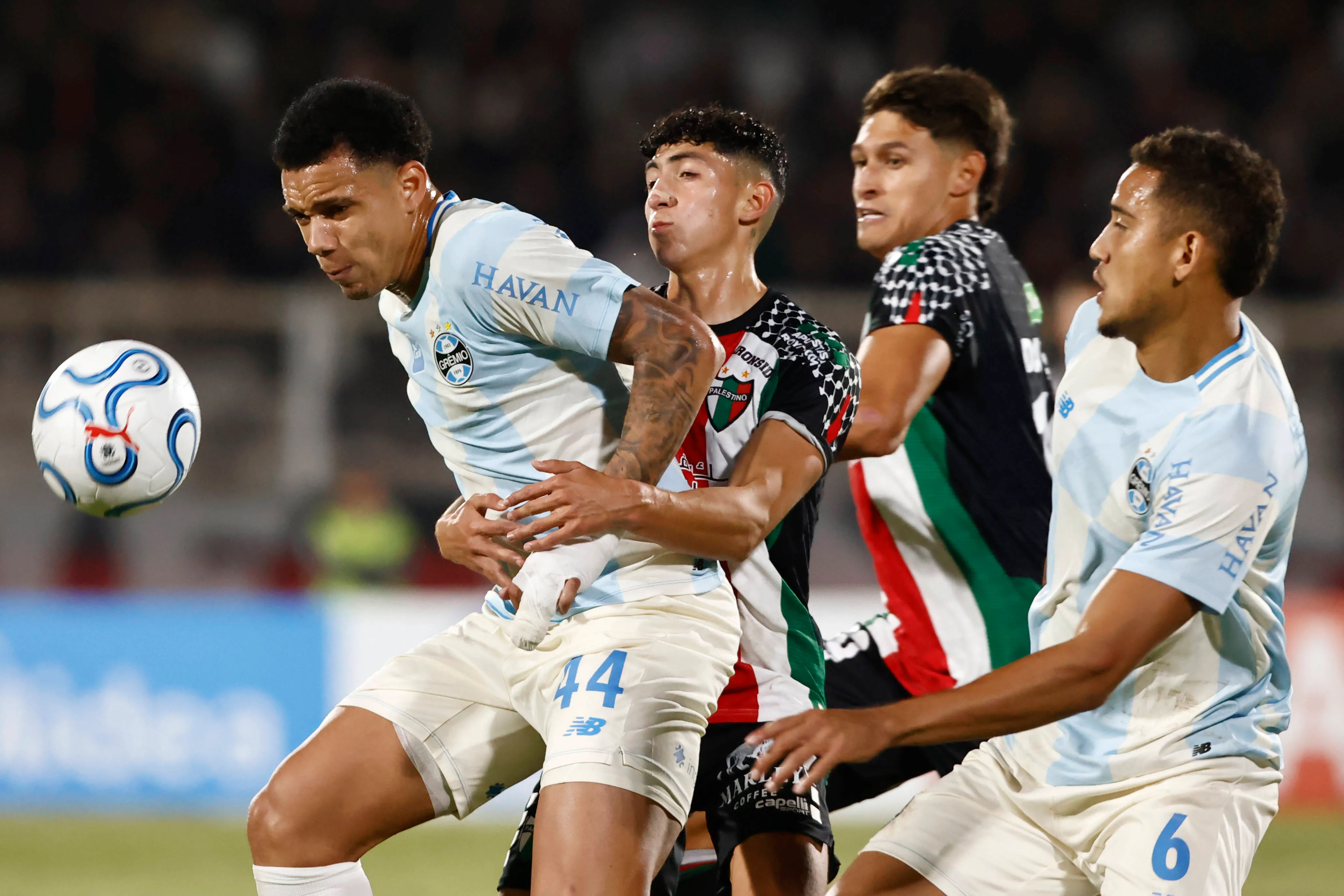 Jogadores em disputa de bola no jogo Palestino x Grêmio. Foto: IMAGO / Photosport
