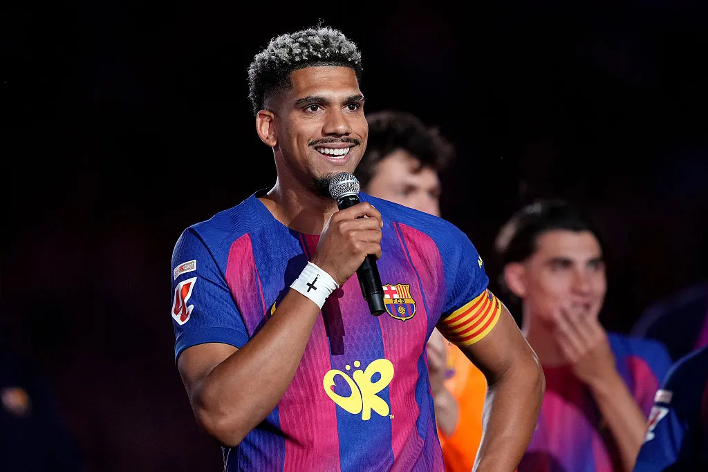 Ronald Araújo, zagueiro do Barcelona, em campo, segurando microfone