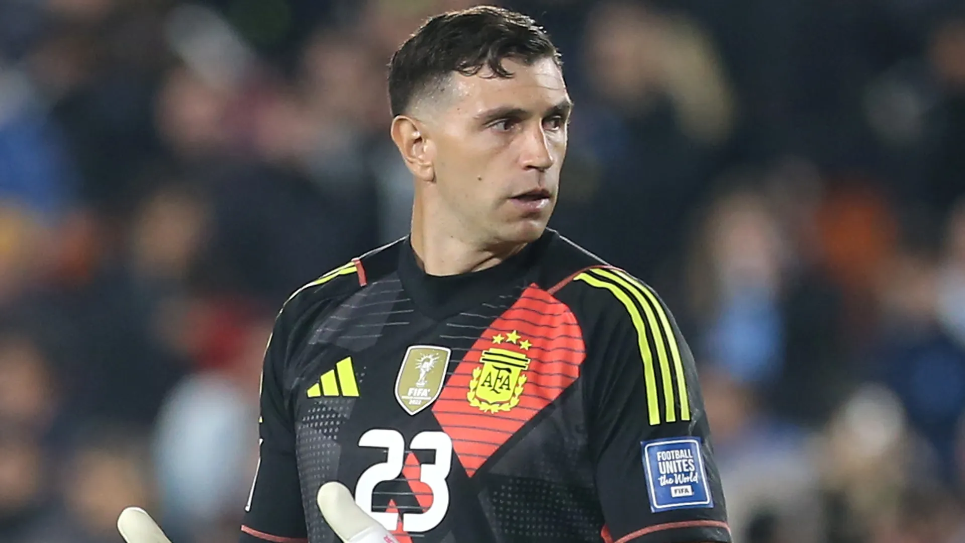 Dibu Martínez aparece olhando para o lado durante um jogo pela Argentina