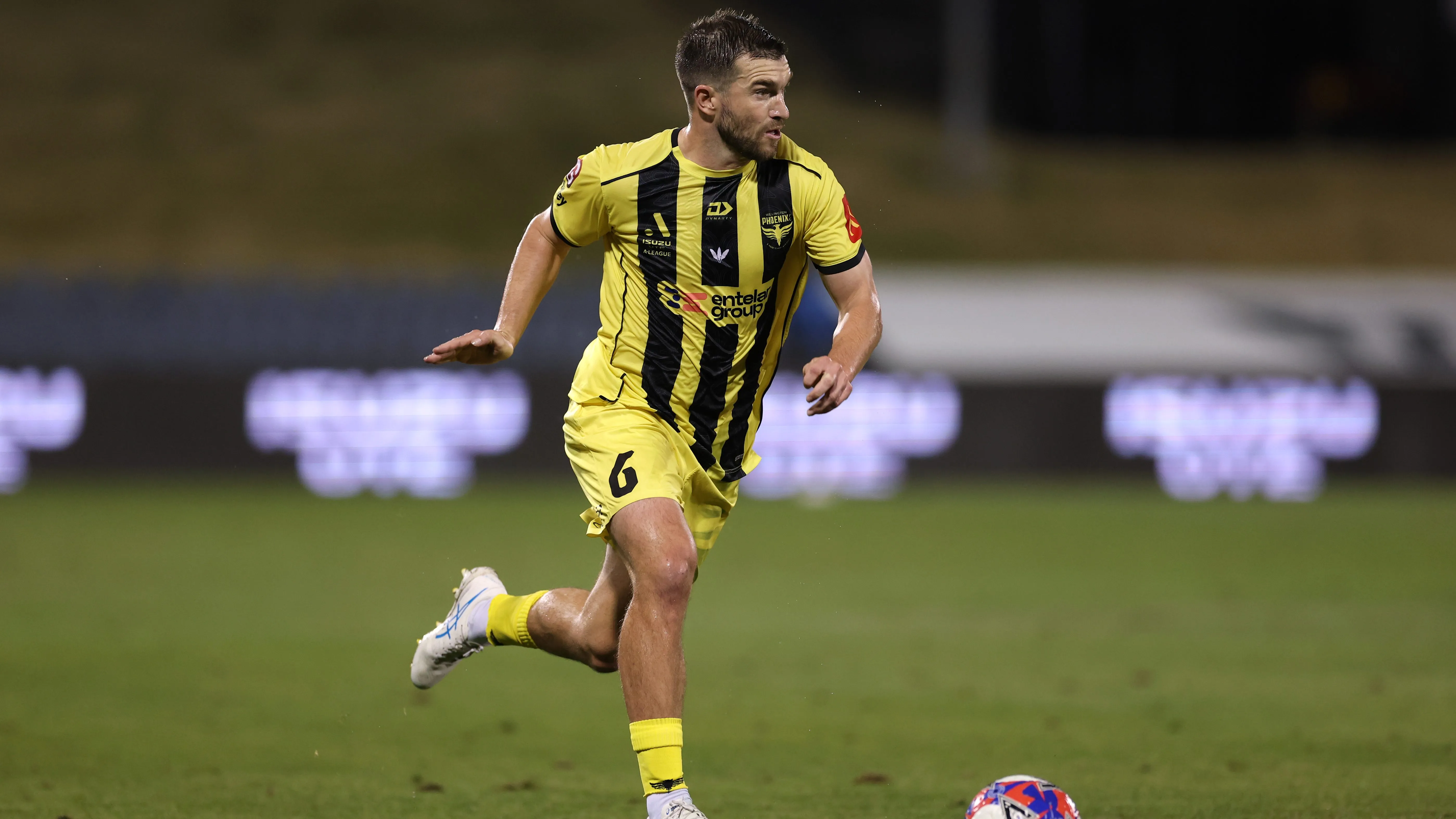 Tim Payne carregando a bola com uniforme amarelo e preto