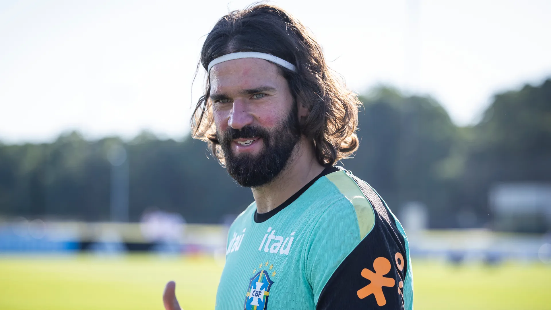 Alisson aparece fazendo sinal de positivo após um treino pelo Brasil