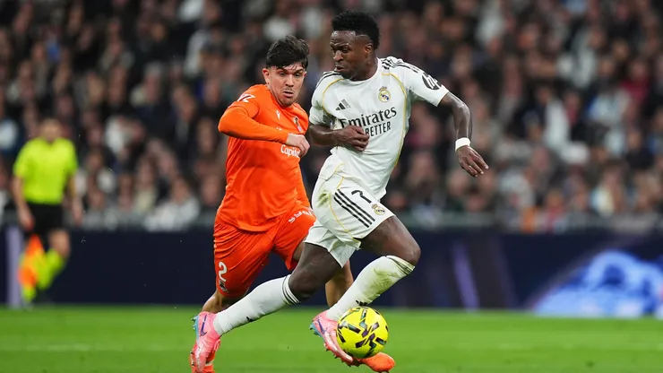Vinicius Junior, do Real Madrid, controla a bola sob pressão de Jon Mikel Aramburu, da Real Sociedad, durante a partida da LaLiga EA Sports entre Real Madrid CF e Real Sociedad no Estádio Santiago Bernabéu, em 14 de fevereiro de 2026, em Madri, Espanha. (Foto de Angel Martinez/Getty Images)