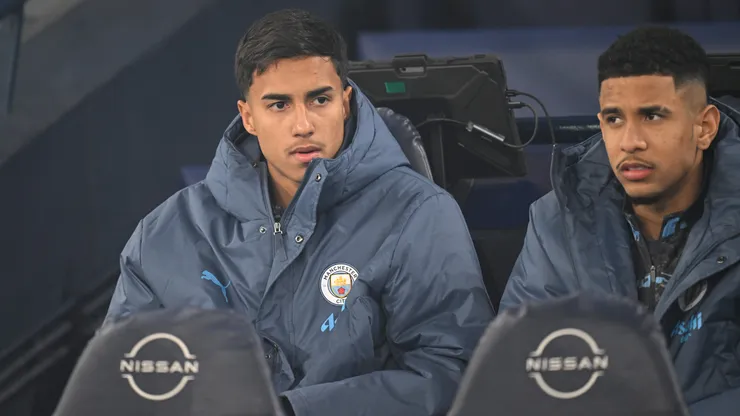 MANCHESTER, ENGLAND - JANUARY 25: Vitor Reis of Manchester City (L) looks on from the substitutes bench prior to the Premier League match between Manchester City FC and Chelsea FC at Etihad Stadium on January 25, 2025 in Manchester, England. (Photo by Michael Regan/Getty Images)