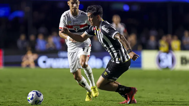 SAO PAULO, BRAZIL - APRIL 20: JP Chermont of Santos runs with the ball in front of Ferreira of Sao Paulo during the Brasileirao 2025 match between Sao Paulo and Santos at MorumBIS on April 20, 2025 in Sao Paulo, Brazil. (Photo by Ricardo Moreira/Getty Images)