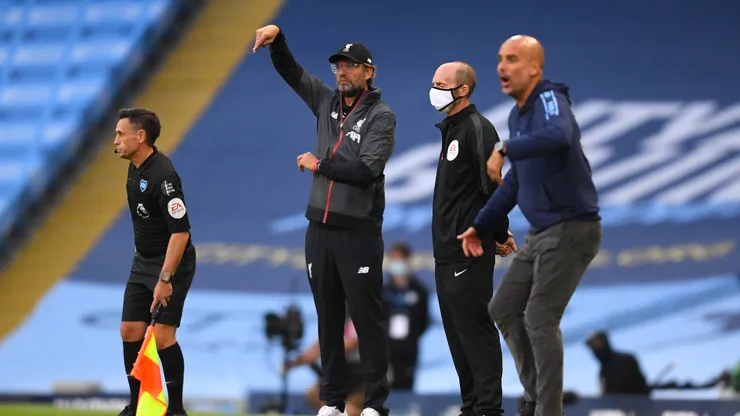 MANCHESTER, ENGLAND - JULY 02: Jurgen Klopp, Manager of Liverpool gives his team instructions as Pep Guardiola, Manager of Manchester City looks on during the Premier League match between Manchester City and Liverpool FC at Etihad Stadium on July 02, 2020 in Manchester, England. Football Stadiums around Europe remain empty due to the Coronavirus Pandemic as Government social distancing laws prohibit fans inside venues resulting in all fixtures being played behind closed doors. (Photo by Laurence Griffiths/Getty Images)