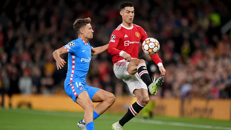 MANCHESTER, ENGLAND - MARCH 15: Marcos Llorente of Atletico Madrid challenges Cristiano Ronaldo of Manchester United during the UEFA Champions League Round Of Sixteen Leg Two match between Manchester United and Atletico Madrid at Old Trafford on March 15, 2022 in Manchester, England. (Photo by Michael Regan/Getty Images)